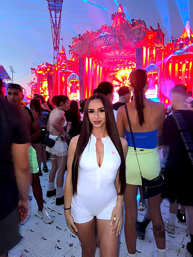 A customer wearing the OMNIA Jumpsuit in white at a festival